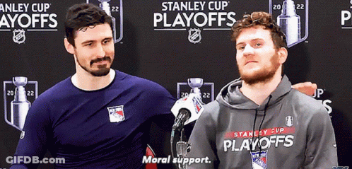 Two Men Are Standing In Front Of A Stanley Cup Playoffs Banner GIF