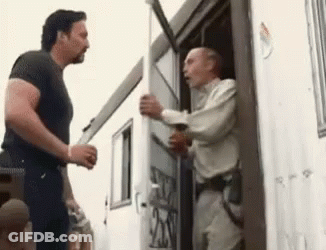 Two Men Are Standing In Front Of A Trailer Talking To Each Other GIF