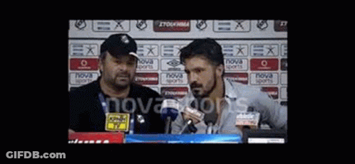 Two Men Are Standing In Front Of Microphones In A Stadium . GIF