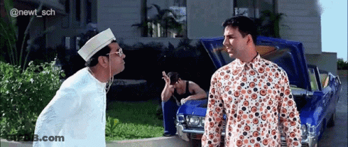 Two Men Are Standing Next To A Blue Car With The Hood Up . GIF