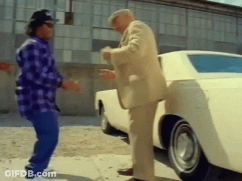 Two Men Are Standing Next To A White Car . GIF