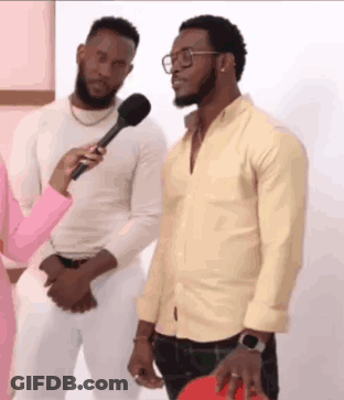 Two Men Are Standing Next To Each Other And A Woman Is Holding A Microphone . One Of The Men Is Wearing Glasses . GIF