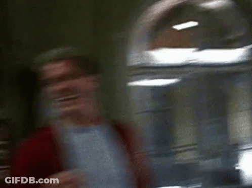 Two Men Are Standing Next To Each Other And Laughing In A Room . GIF