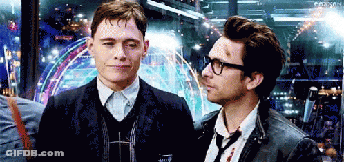 Two Men Are Standing Next To Each Other And Looking At Each Other . One Of The Men Is Wearing Glasses . GIF