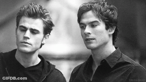 Two Men Are Standing Next To Each Other And Looking At Each Other . GIF