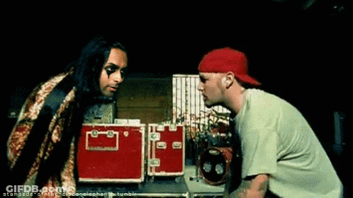 Two Men Are Standing Next To Each Other And One Has A Red Hat GIF