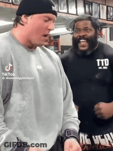 Two Men Are Standing Next To Each Other And One Has A Shirt That Says Ttd GIF