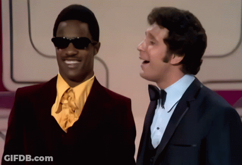 Two Men Are Standing Next To Each Other And One Has Sunglasses On GIF