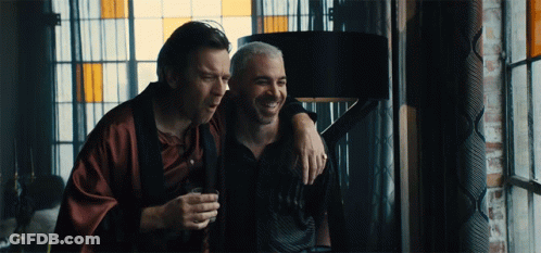 Two Men Are Standing Next To Each Other And One Is Holding A Glass GIF