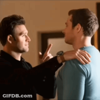 Two Men Are Standing Next To Each Other And One Man Is Pointing At The Other . GIF