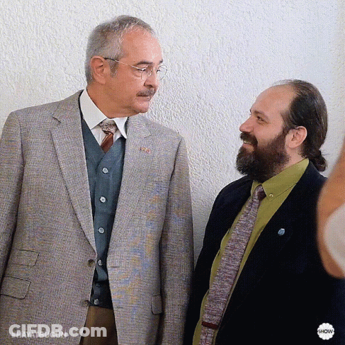 Two Men Are Standing Next To Each Other And One Of Them Has A Badge That Says Hayatbugon GIF