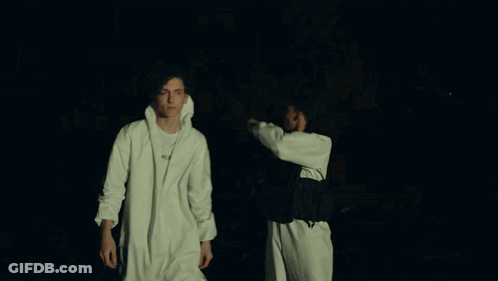 Two Men Are Standing Next To Each Other And One Of Them Has A Nike Necklace Around His Neck GIF