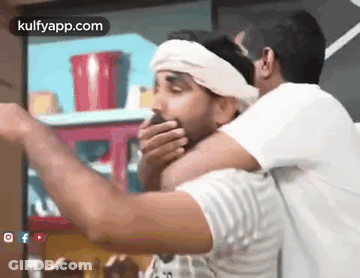 Two Men Are Standing Next To Each Other And One Of Them Is Covering His Mouth With His Hand . GIF