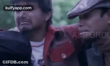 Two Men Are Standing Next To Each Other And One Of Them Is Holding Another Man 'S Hand . GIF
