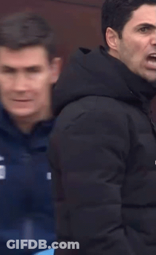 Two Men Are Standing Next To Each Other And One Of Them Is Pointing At The Camera . GIF