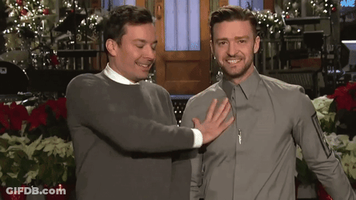 Two Men Are Standing Next To Each Other And One Of Them Is Touching The Chest Of The Other GIF