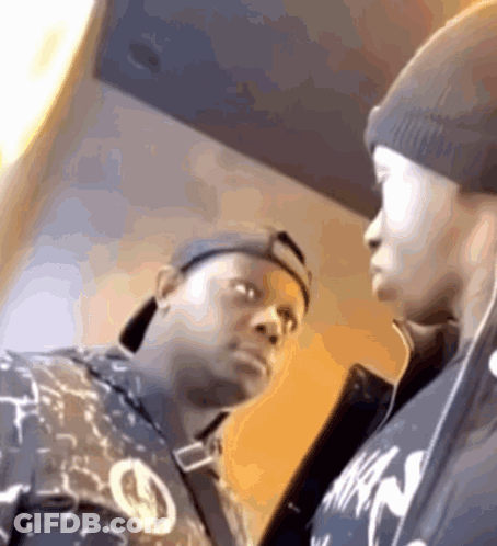 Two Men Are Standing Next To Each Other And One Of Them Is Wearing A Shirt That Says Nike GIF