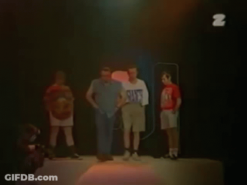 Two Men Are Standing Next To Each Other And One Of Them Is Wearing A White Shirt With The Letter Z On It . GIF