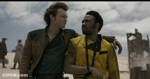 Two Men Are Standing Next To Each Other And One Of Them Is Wearing A Yellow Shirt That Says ' A ' On It GIF