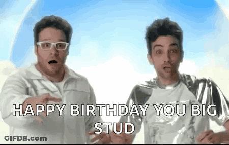 Two Men Are Standing Next To Each Other And One Of Them Is Wearing Glasses And The Other Is Wearing A Silver Shirt . GIF