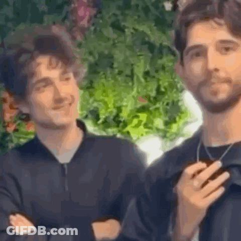 Two Men Are Standing Next To Each Other And Smiling . GIF
