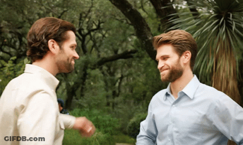 Two Men Are Standing Next To Each Other And Talking GIF