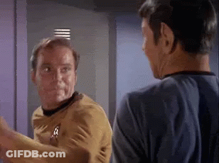 Two Men Are Standing Next To Each Other And Talking In A Room . GIF