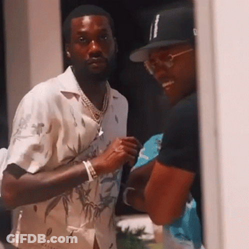 Two Men Are Standing Next To Each Other And Talking . One Of The Men Is Wearing A Hat . GIF