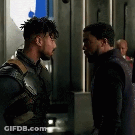 Two Men Are Standing Next To Each Other And Talking To Each Other In A Dark Room . GIF