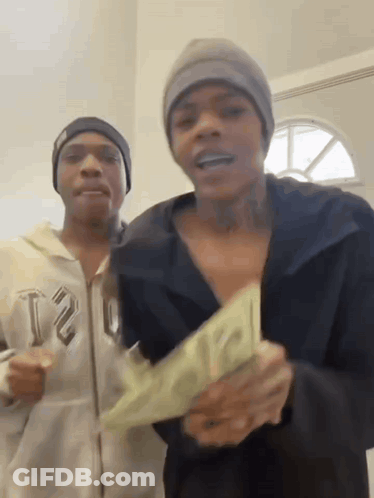 Two Men Are Standing Next To Each Other Holding A Large Amount Of Money . GIF
