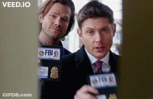 Two Men Are Standing Next To Each Other Holding Badges That Say Fbi GIF
