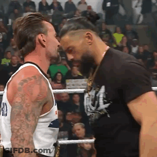 Two Men Are Standing Next To Each Other In A Boxing Ring And Looking At Each Other . GIF
