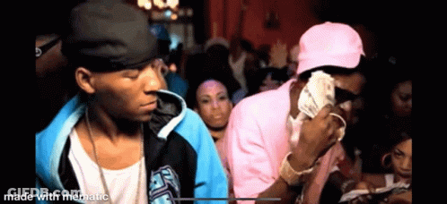 Two Men Are Standing Next To Each Other In A Crowd Of People . GIF