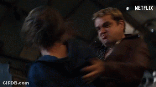 Two Men Are Standing Next To Each Other In A Dark Room And One Of Them Is Making A Funny Face . GIF