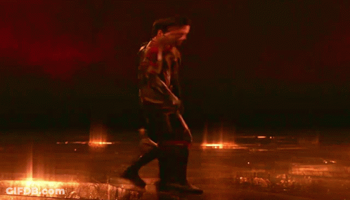 Two Men Standing Next To Each Other In Dark Room GIF