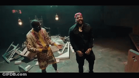 Two Men Are Standing Next To Each Other In A Dark Room . GIF