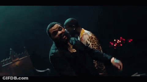 Two Men Are Standing Next To Each Other In A Dark Room In Front Of A Candle Holder . GIF