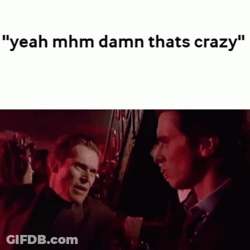 Two Men Are Standing Next To Each Other In A Dark Room Talking To Each Other . GIF