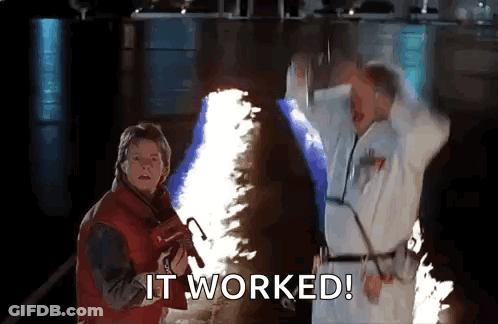 Two Men Are Standing Next To Each Other In A Dark Room With A Flame Coming Out Of Their Hands . GIF