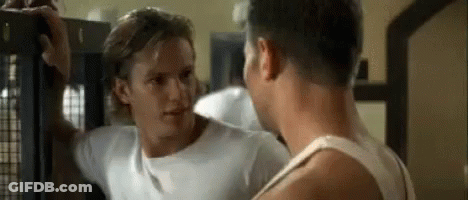 Two Men Are Standing Next To Each Other In A Gym And Talking . GIF