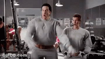 Two Men Are Standing Next To Each Other In A Gym With Their Arms Outstretched . GIF