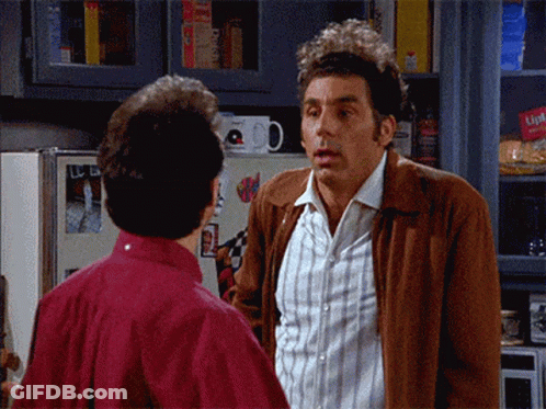 Two Men Are Standing Next To Each Other In A Kitchen And One Of Them Is Wearing A Brown Jacket That Says Lipton On It GIF