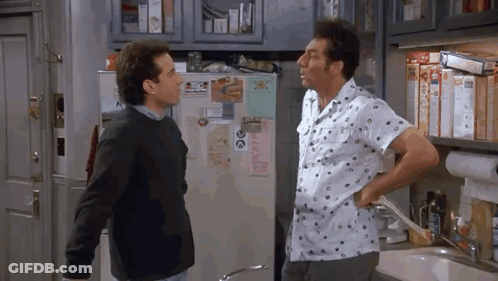 Two Men Are Standing Next To Each Other In A Kitchen Talking . GIF
