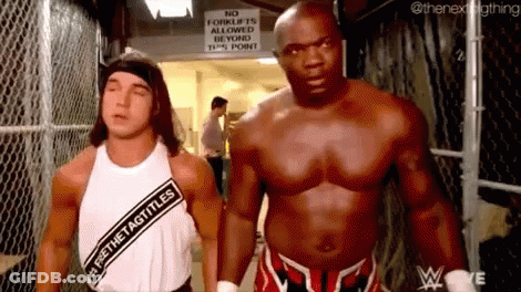 Two Men Are Standing Next To Each Other In A Locker Room . GIF