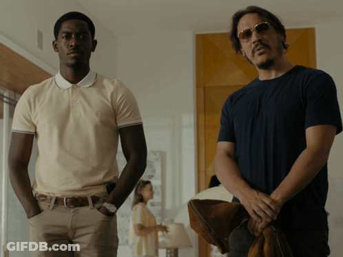 Two Men Are Standing Next To Each Other In A Room GIF