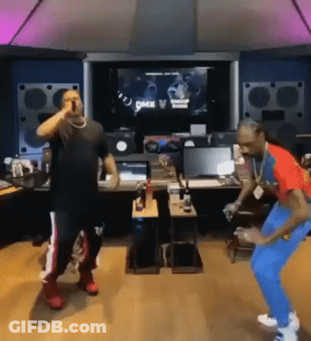 Two Men Are Standing Next To Each Other In A Room And Dancing In Front Of A Microphone . GIF
