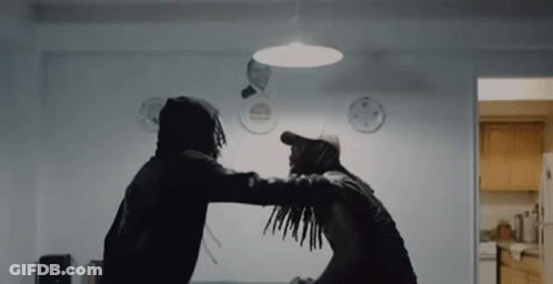 Two Men Are Standing Next To Each Other In A Room And Fighting . GIF