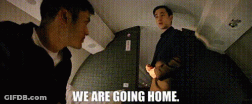 Two Men Are Standing Next To Each Other In A Room And The Words `` We Are Going Home '' Are Written On The Screen . GIF