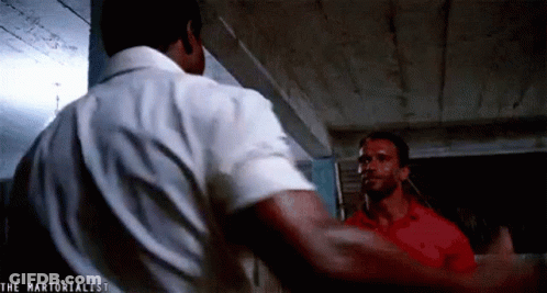 Two Men Are Standing Next To Each Other In A Room . GIF