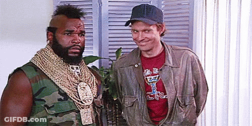 Two Men Are Standing Next To Each Other In A Room . One Of The Men Is Wearing A Hat . GIF